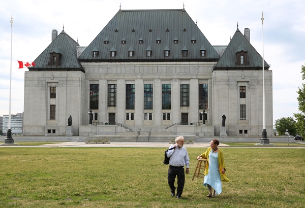 Irving and Rosalie Abella walk together on the lawn of the Supreme Court of Canada on her last day of hearings