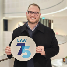 GPLLM student, Claudio Klaus holding a law 75 sign