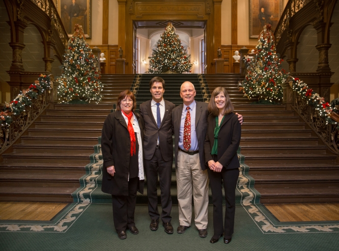 Ontario MPP Eric Hoskins centre with Dean Mayo Moran and AODA stakdholders inside Queen's Park decorated with Christmas trees.